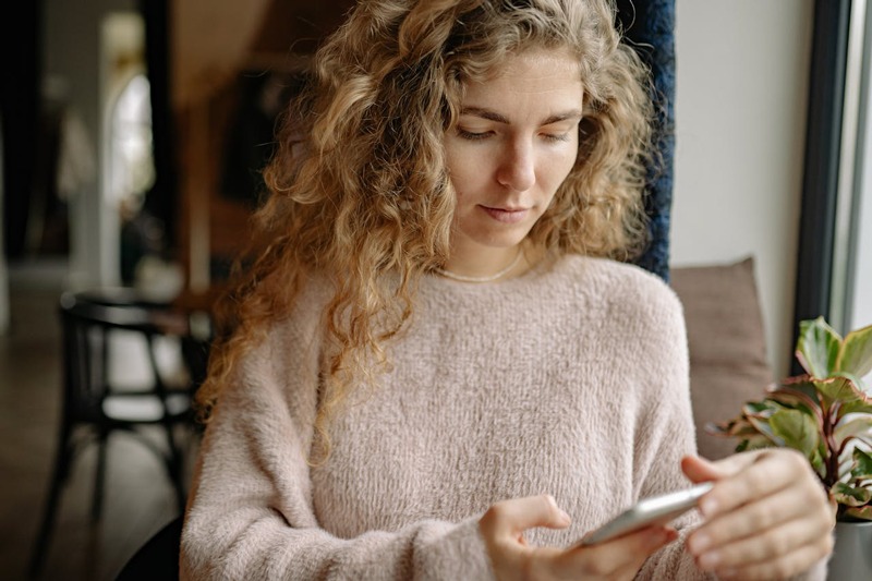 A woman calmly reading a message on her phone